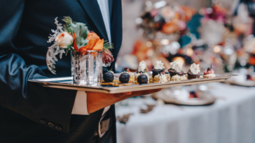 A cater waiter holding a tray of food.