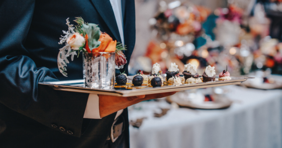 A cater waiter holding a tray of food.