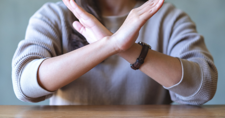 A woman crossing her arms, saying no.