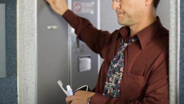 Man knocking on airplane bathroom door