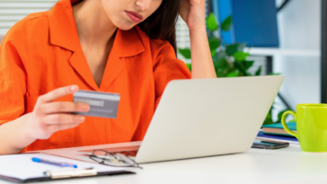 woman with credit card looking at laptop screen