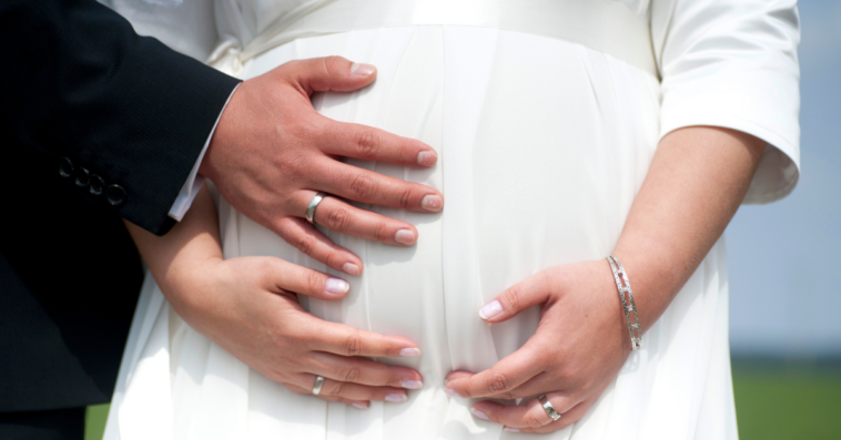 Pregnant bride with groom