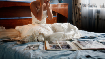 Bride crying on bed looking at photos