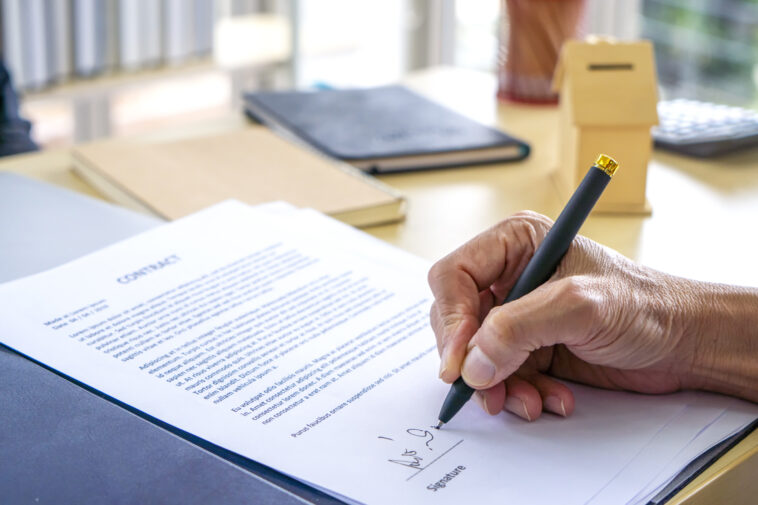 Person signing life insurance paperwork