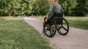 A woman in a wheelchair on the road.