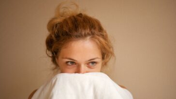 Woman snuggling with white blanket