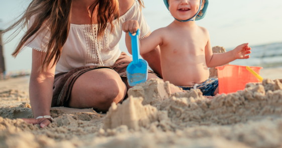 adult and child on beach playing in the sand