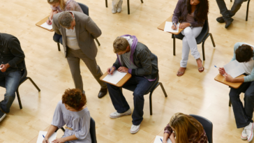 group of young adults supervised taking a test