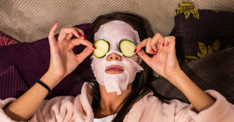 woman with facial treatment mask and cucumbers on eyes