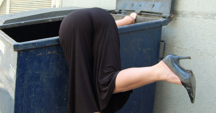 woman searching in dumpster