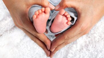 Baby's Feet In Heart Shaped Hands