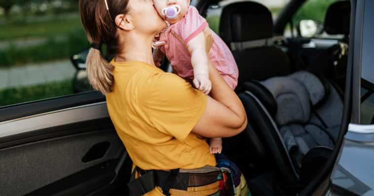 Mom putting her baby into a carseat