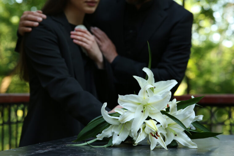 Couple standing together at funeral