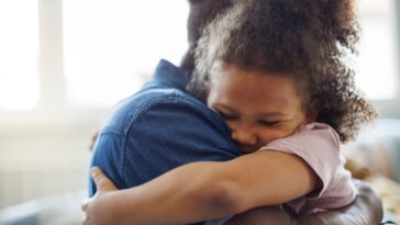 Father and daughter embracing at home.