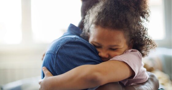 Father and daughter embracing at home.