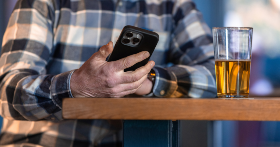 Man drinking and looking at his phone