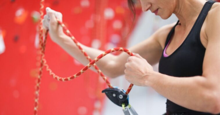 A young woman adjusts her safety harness.