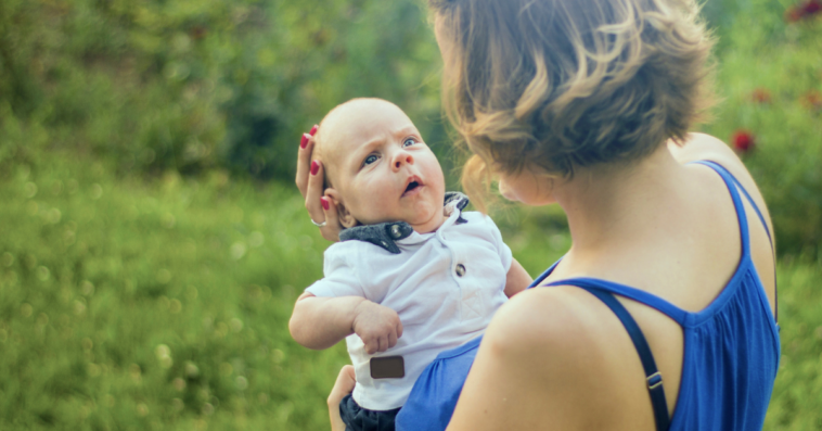 Woman holding baby away from her