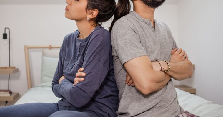 Couple with backs against each other in anger