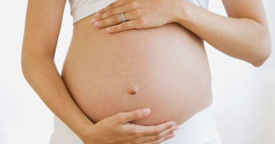 A pregnant woman holding her belly.