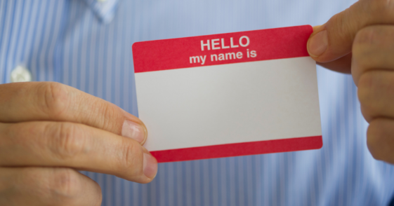 person holding blank adhesive name tag