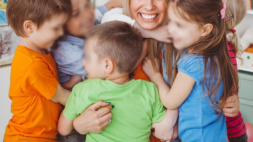 children hugging their teacher