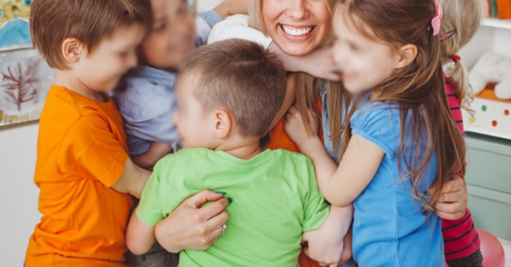 children hugging their teacher