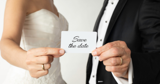 bride and groom holding 'save the date' card