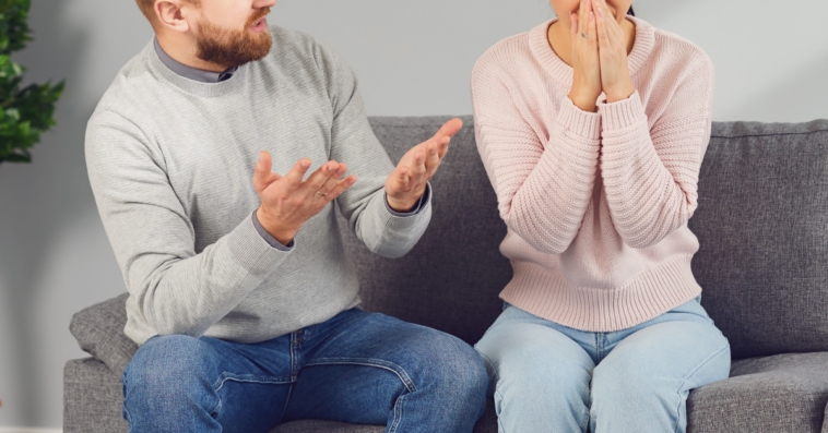 couple seated on couch arguing