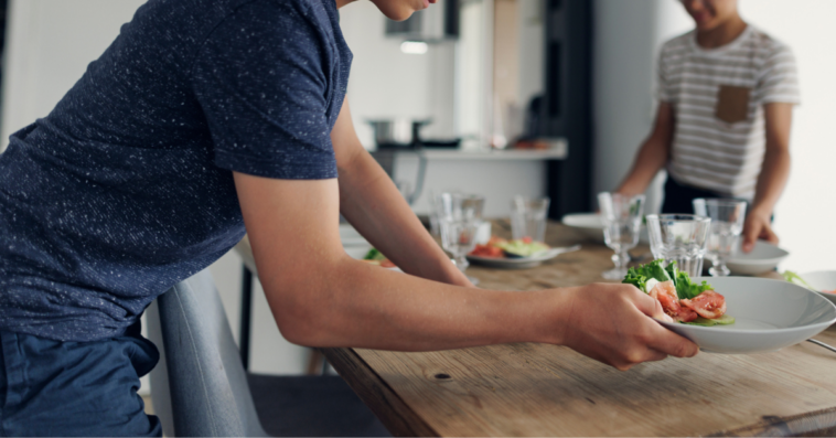 Teen boy setting the table