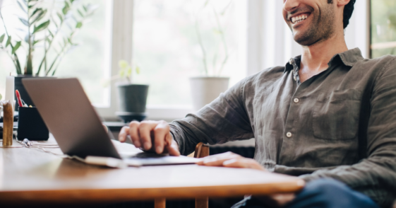 Man laughing at computer screen