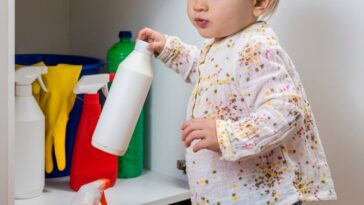 Little girl playing with household cleaners.