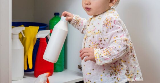 Little girl playing with household cleaners.