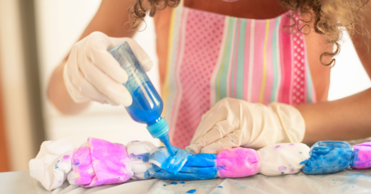 Woman tie-dyeing a dress