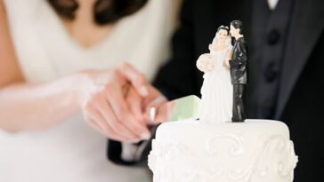 Newlyweds cutting wedding cake.