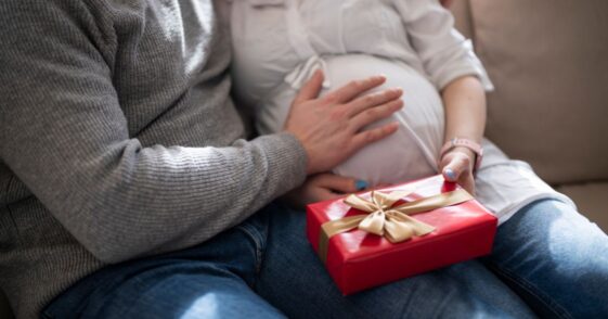 Pregnant woman holding a present from her husband