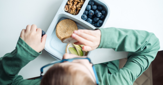 A boy eating from a lunchbox