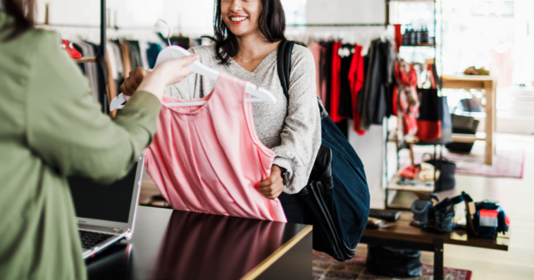 A woman buying a pink dress.