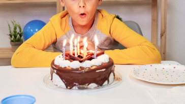 A Boy blowing out birthday candles.