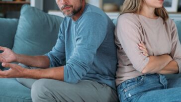 Man and woman with relationship problems sitting on sofa and not talking to each other.