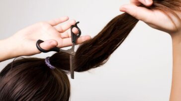 Woman cutting her ponytail.