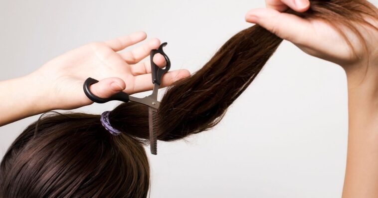 Woman cutting her ponytail.