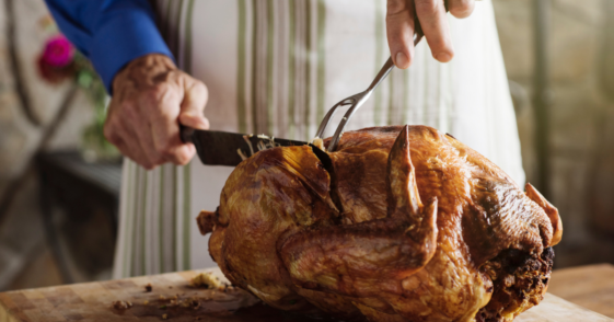 A man carving a turkey.