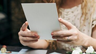 A woman prepares a wedding invitation card.