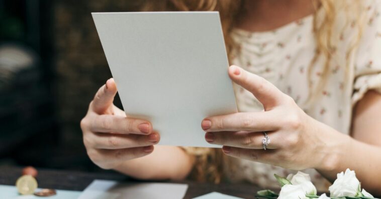 A woman prepares a wedding invitation card.