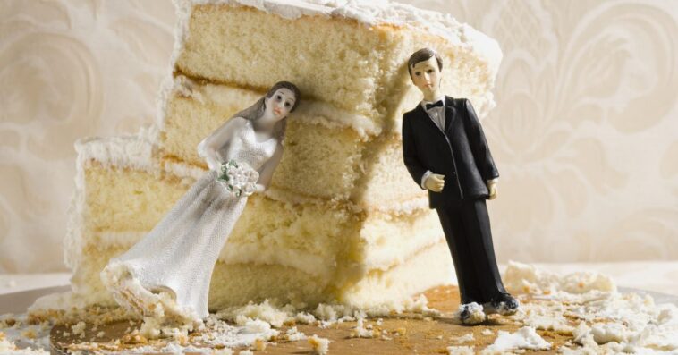 Wedding cake visual metaphor with figurine cake toppers. The toppers of a bride and groom are leaning against a crumbled piece of vanilla wedding cake.