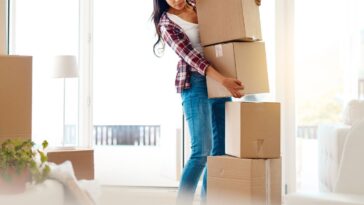 Woman holding a stack of moving boxes