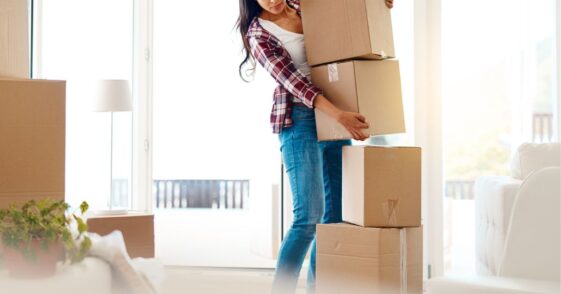 Woman holding a stack of moving boxes