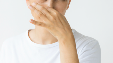 A woman plugging her nose.