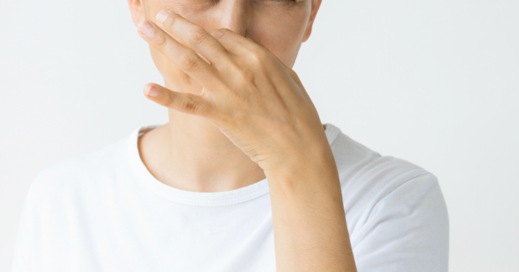 A woman plugging her nose.